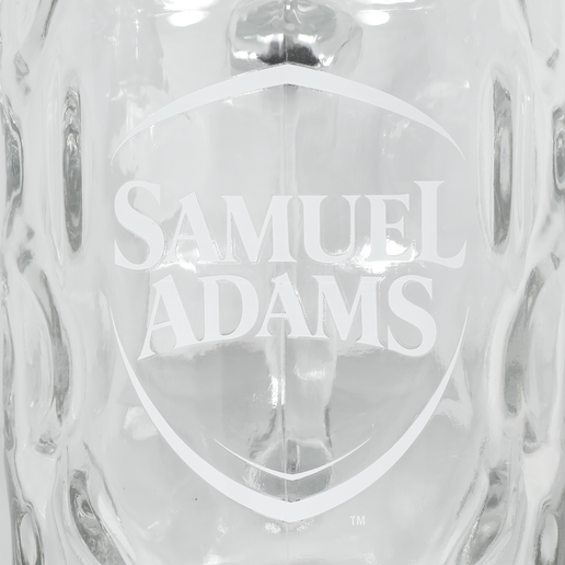 A close-up shot of the white Samuel Adams logo on the front of the beer glass.