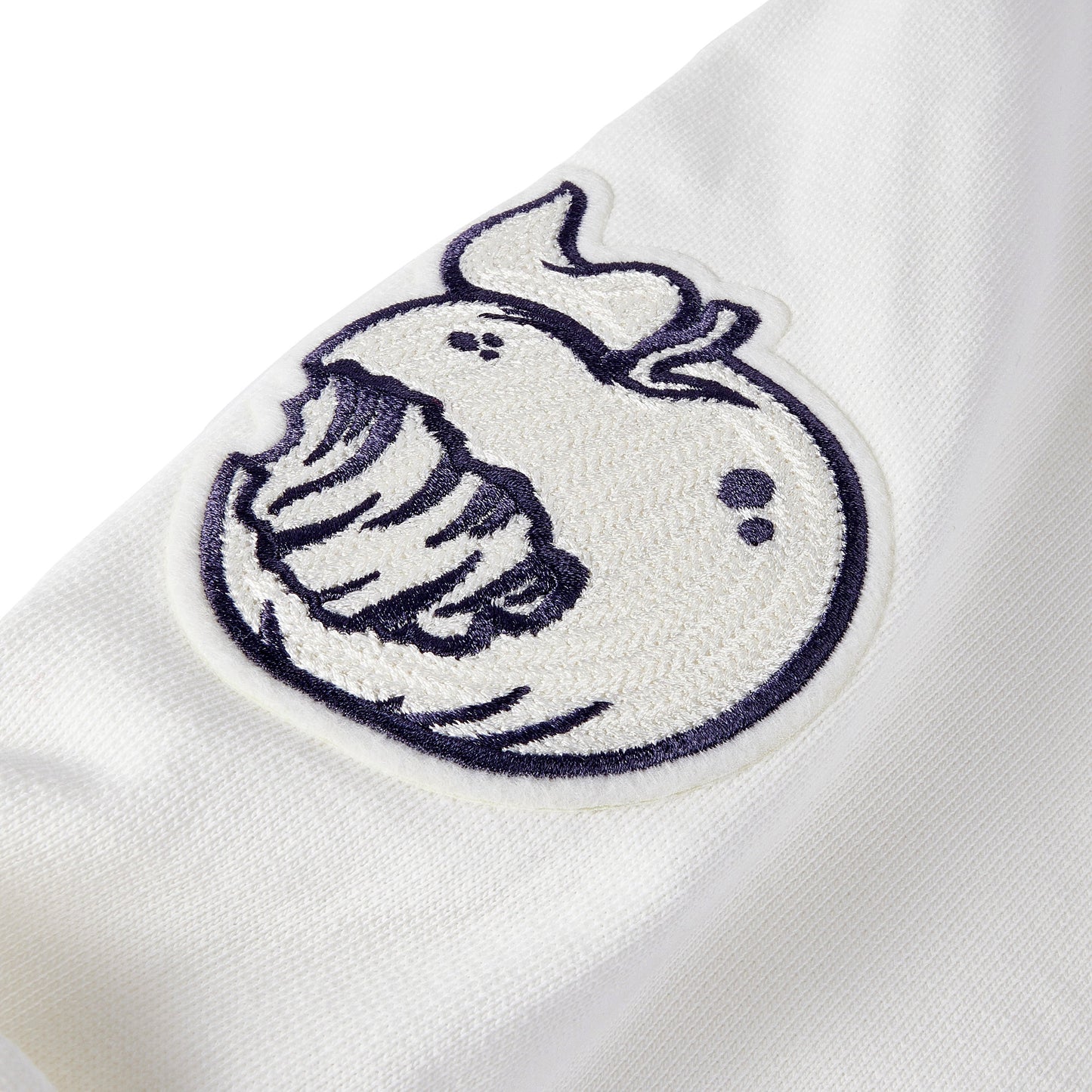 Detail shot of the Angry Orchard White Walden Crew Sweatshirt sleeve embroidery of an Angry Orchard Apple