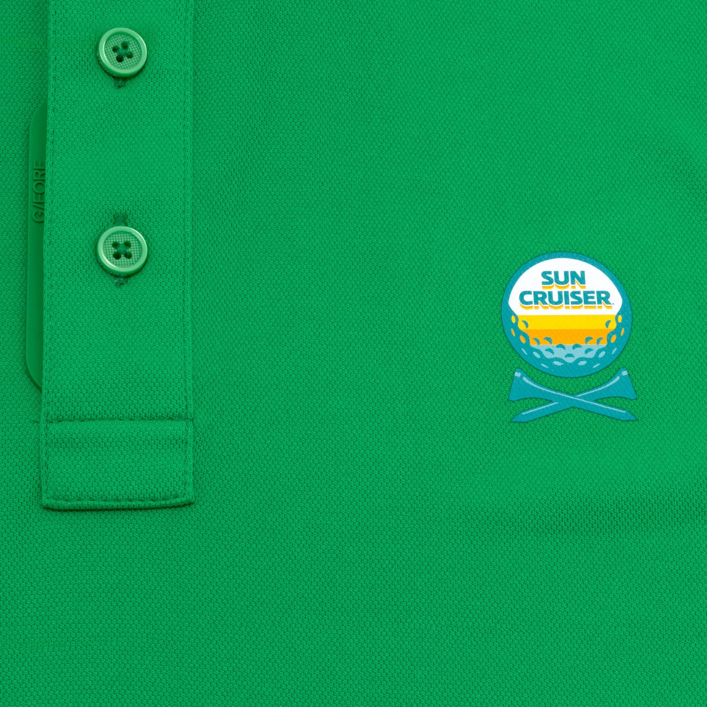 Sun Cruiser x G/FORE green golf polo close-up featuring textured performance fabric, branded button placket, and embroidered chest logo detail