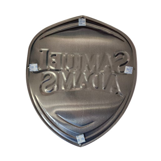 A Sam Shield Logo Tacker. Size is approximately 18.5" long and 16.5" wide. There are 4 holes for hanging or self-adhesive strips on the back.