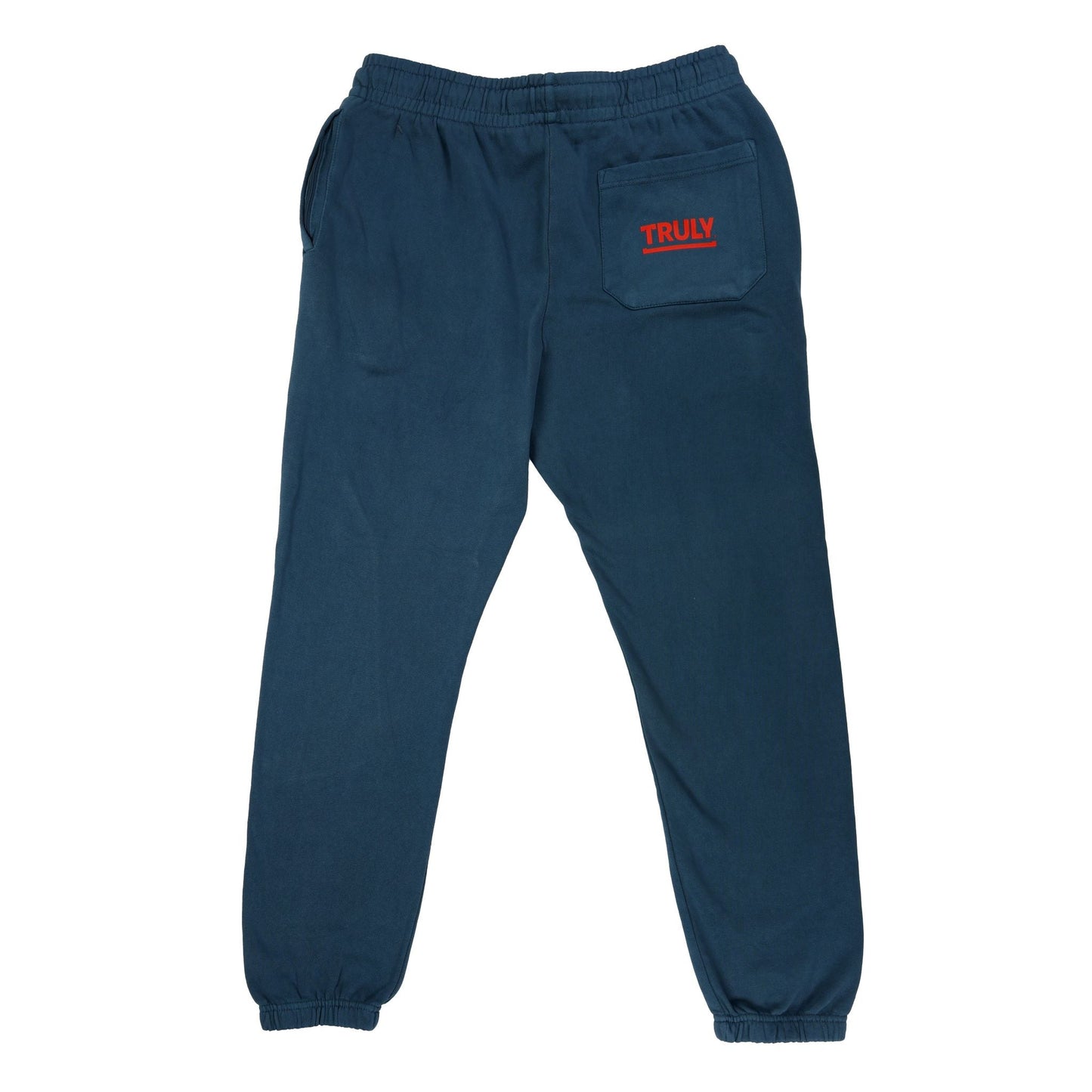 A pair of dark blue sweatpants, viewed from the back. They feature an elastic waistband and ribbed cuffs at the ankles. On the upper right side of the back, above a small pocket, the word "TRULY" is printed in red text. There is also a pocket on the left side, visible at the hip.