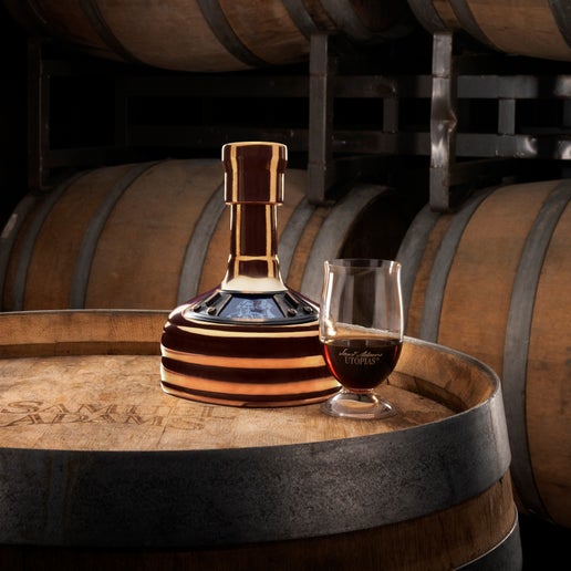 Sam Adams Utopias Glass and Bottle, sitting on top of a barrel