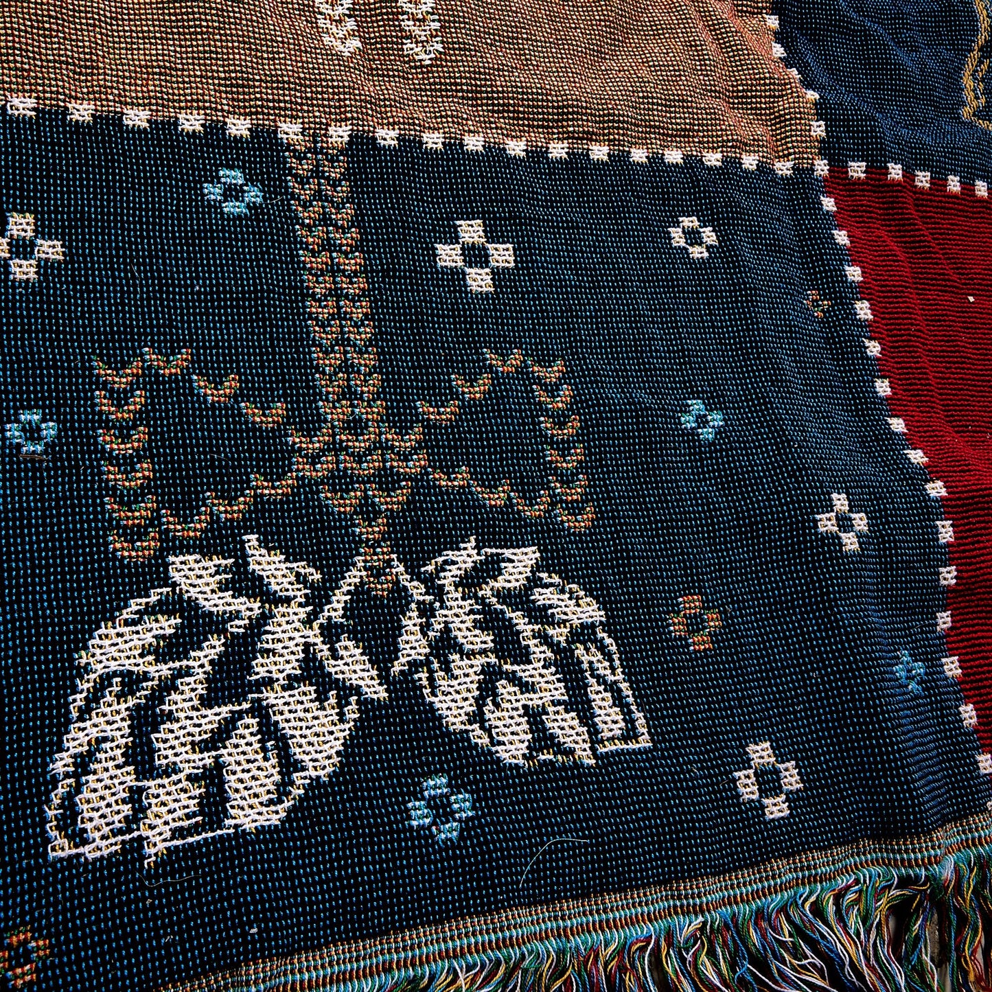 Close up of Navy square on Winter Tapestry Blanket 62 x 54. Navy square has a gold bow and white mistletoe design