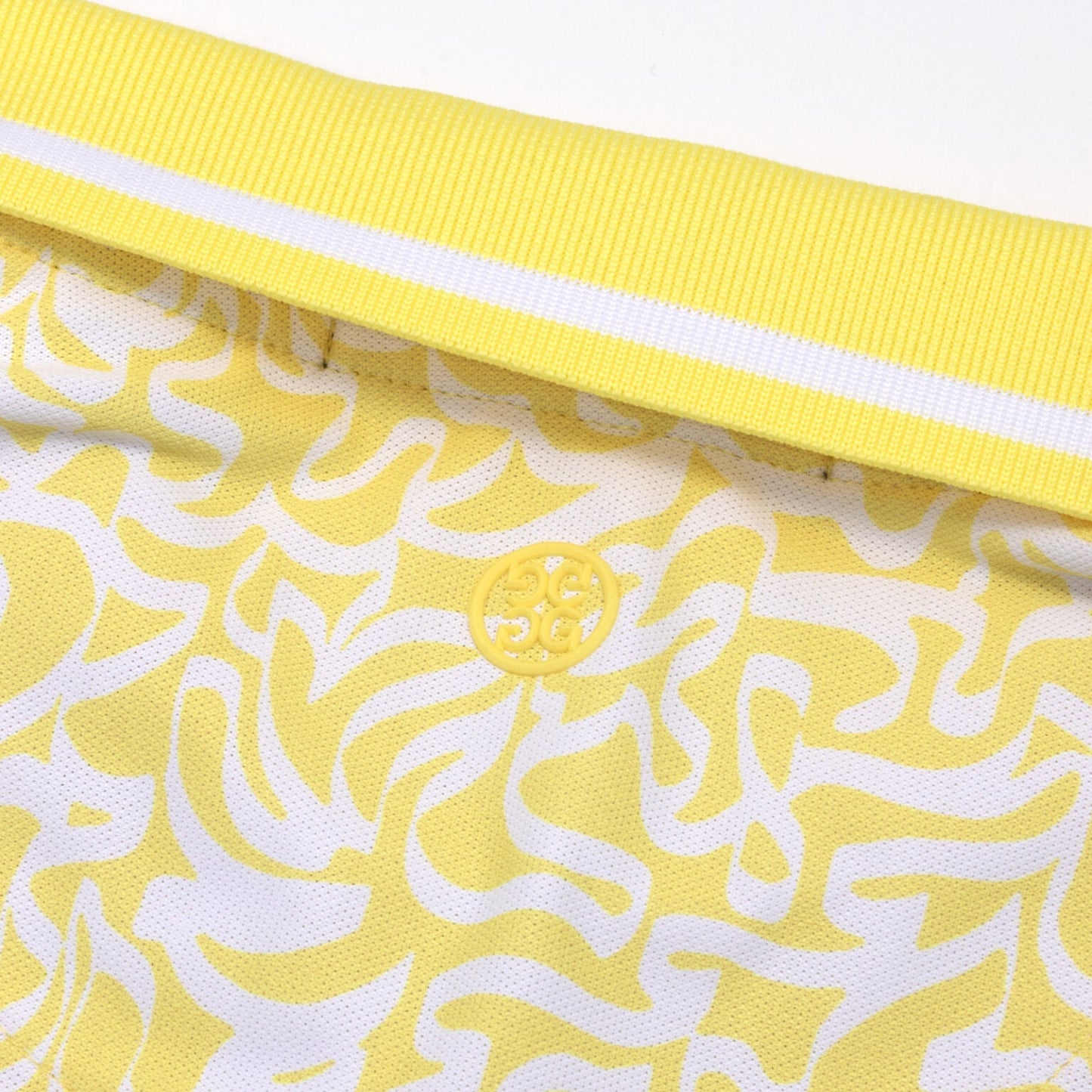 Yellow sleeveless polo shirt with white stripe ribbed collar and textured abstract pattern, and Circle G golf apparel detail