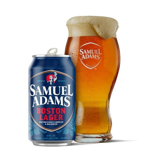 A 16oz pint glass filled with beer with the Samuel Adams classic shield logo printed on the front in white, with a can of Samuel Adams Boston Lager next to it.