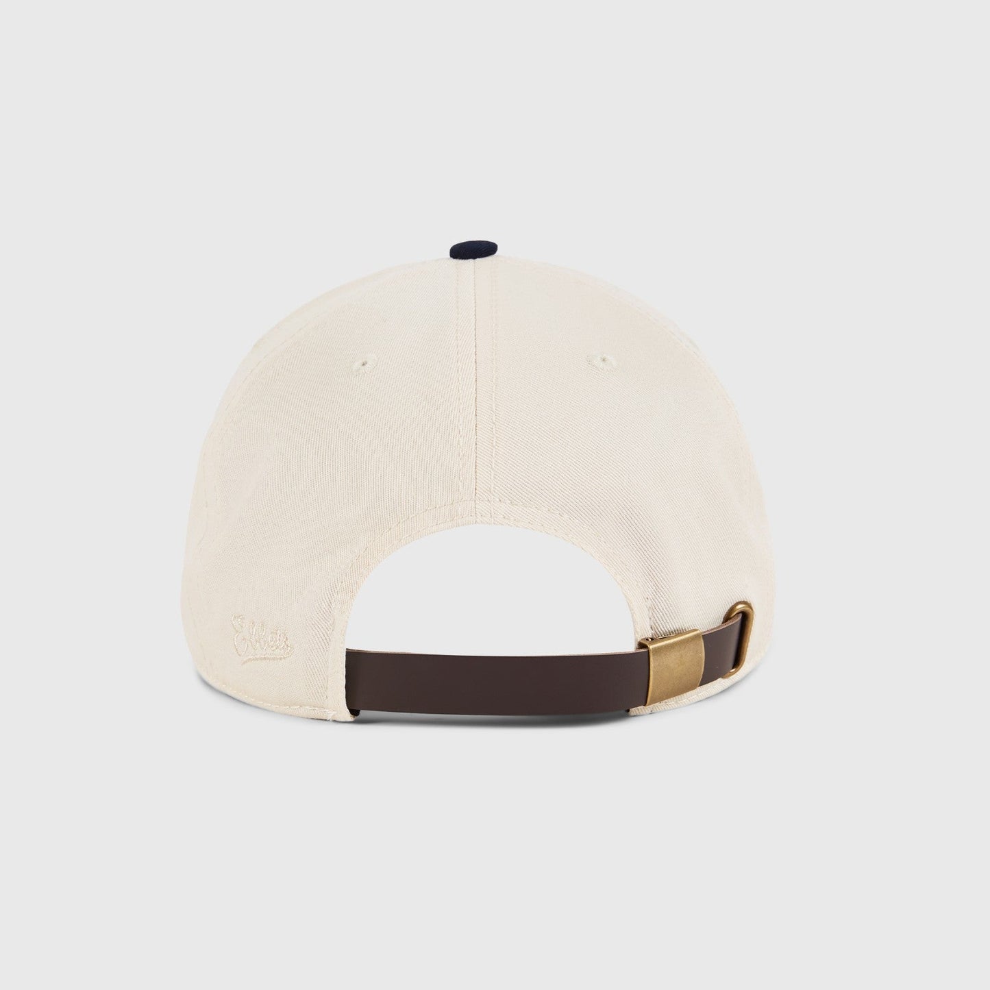 Beige cap with brown and gold strap on a light gray background