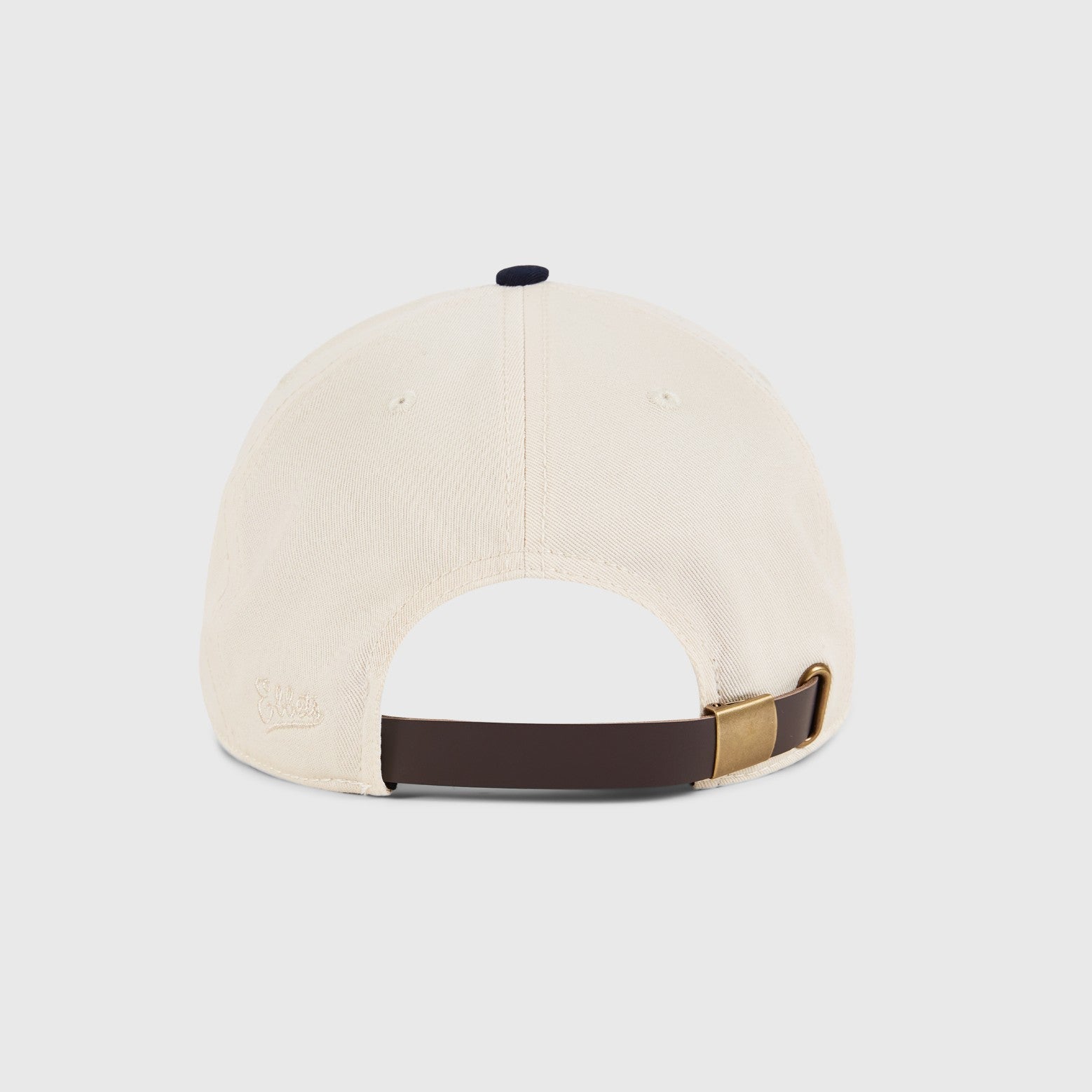 Beige cap with brown and gold strap on a light gray background