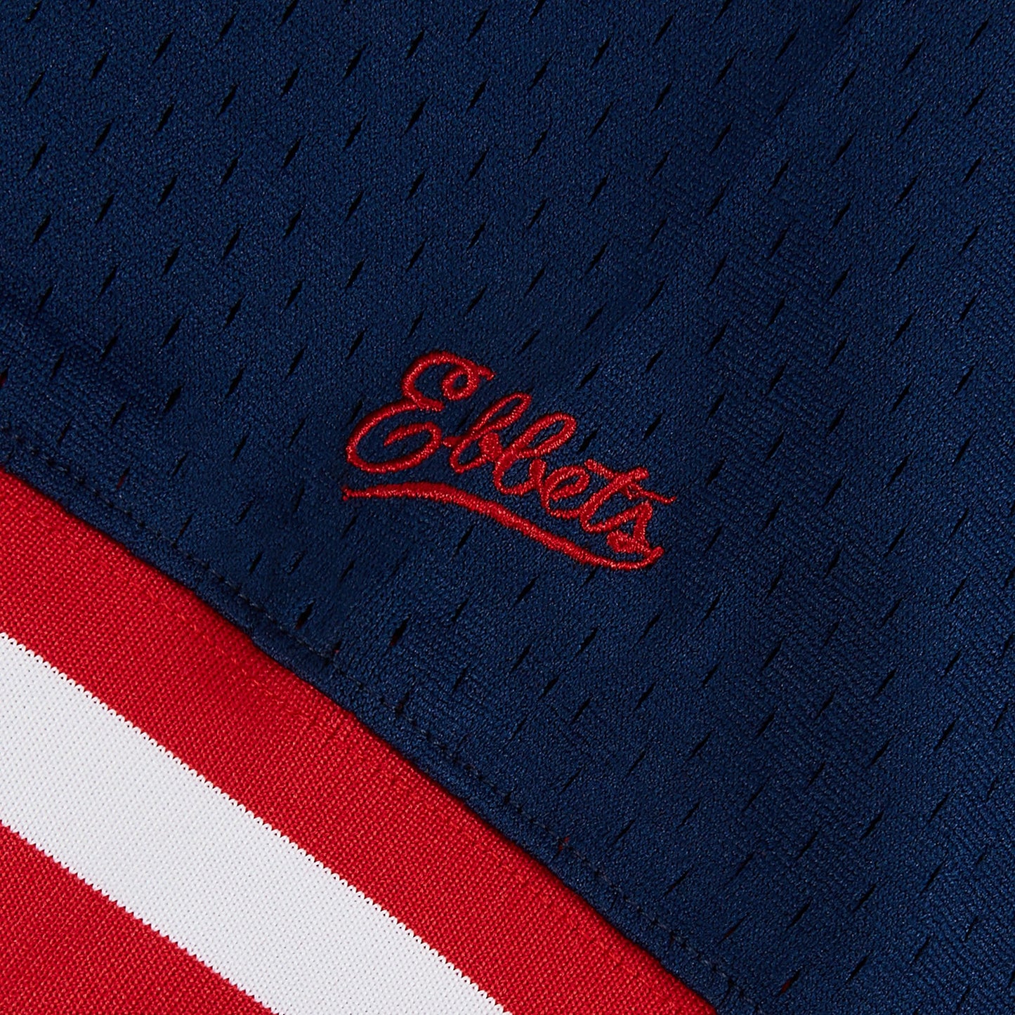 Close-up of a blue sports jersey with red and white accents and 'Ebbets' logo.