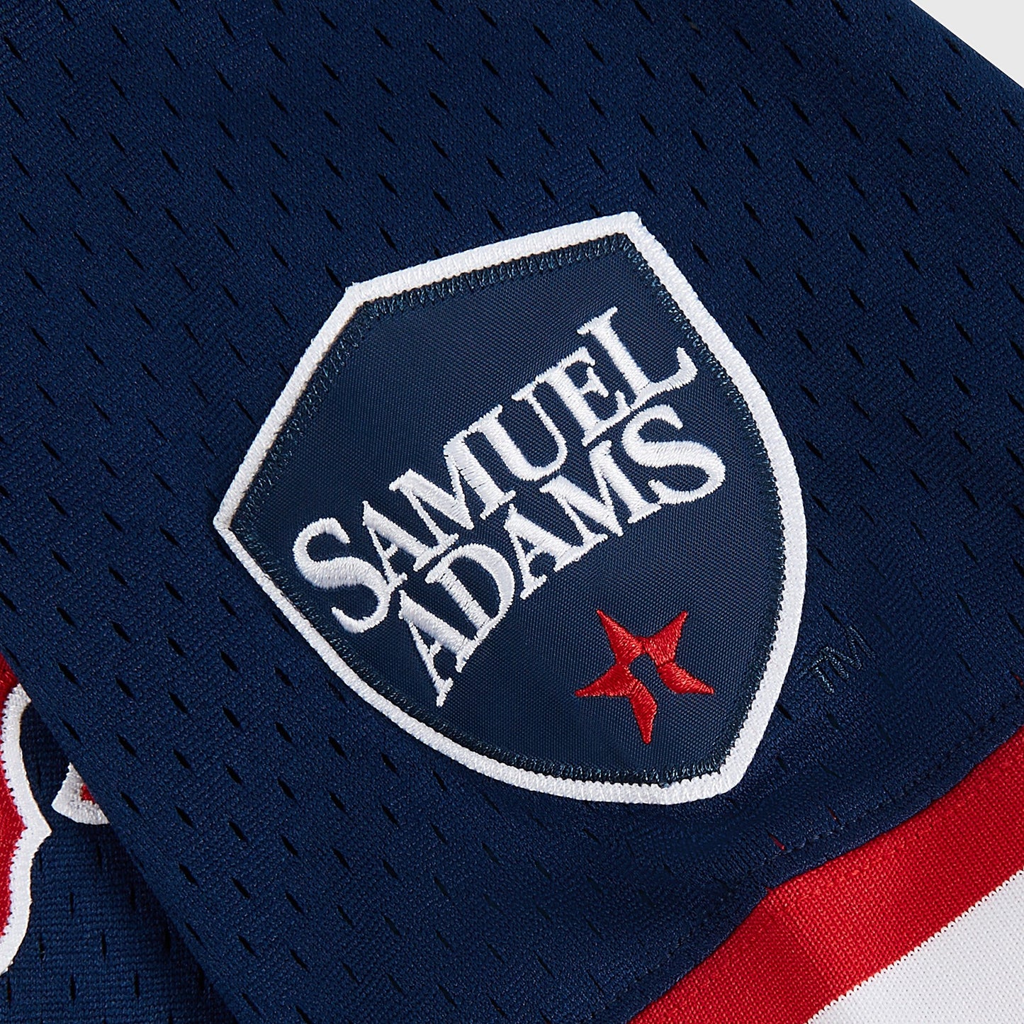 Samuel Adams logo on a sports jersey with red and white accents