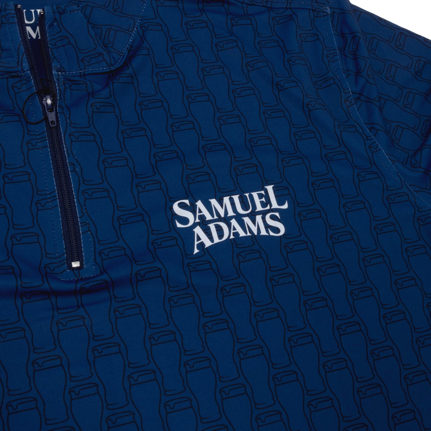 Close-up of Samuel Adams Perfect Pint quarter zip pullover in navy blue featuring subtle pint glass pattern and embroidered Samuel Adams logo on chest