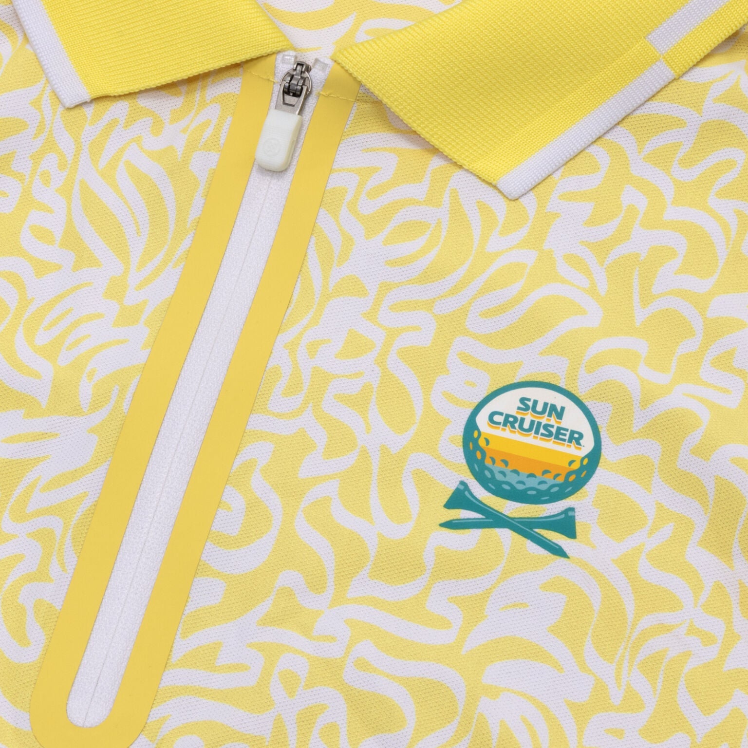 Sun Cruiser sleeveless golf polo close-up with yellow and white abstract print, quarter-zip placket, and embroidered logo detail