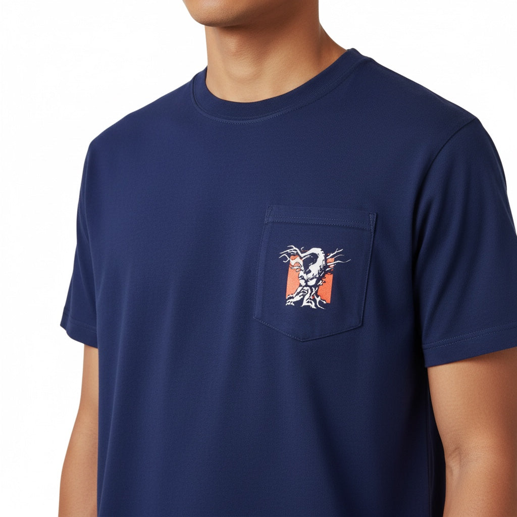 A blue crewneck tee shirt with a pocket .The pocket has the Angry Orchard Tree logo against a red square. The shirt is worn by a person. 
