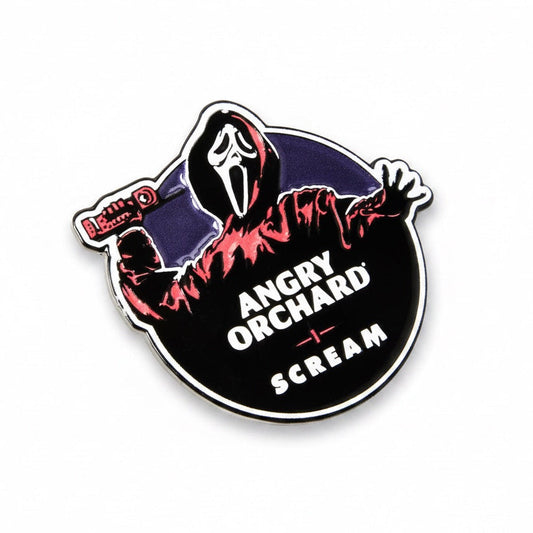 A circular enamel pin featuring the Ghostface character from Scream in a red hoodie, with the text 'ANGRY ORCHARD + SCREAM' and a 'Hello' sign on a plain white background.