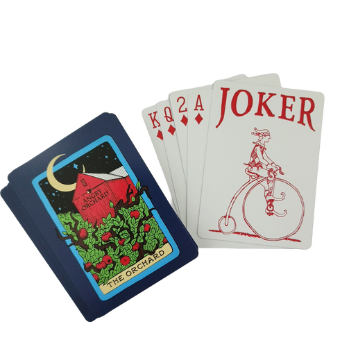 The box and outside of these playing cards display a design of a moonlit orchard on a tarot card. The "name" on the tarot card is "The Orchard".