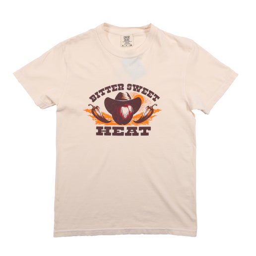 The front of this tee displays an apple wearing a cowboy hat with a chili pepper on each side of it. The word "Bittersweet" is arched over the apple and below the apple is the word "HEAT".
