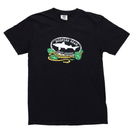 The Black IPA Short Sleeve Tee by GO WEST T-SHIRT COMPANY features a white oval logo with a shark silhouette, green hops, and Dogfish Head Craft Brewery’s branding in white, honoring their iconic 60 Minute IPA.