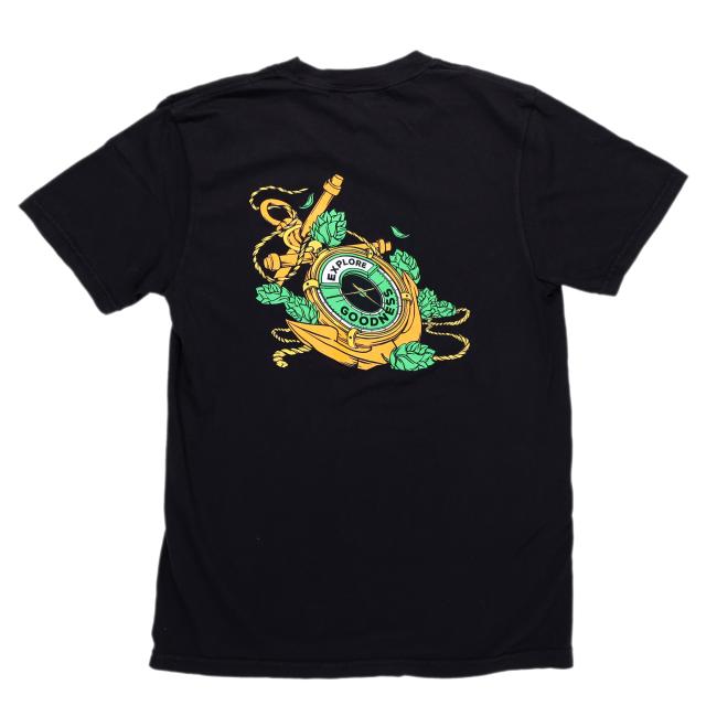 The GO WEST T-SHIRT COMPANY Black IPA Short Sleeve Tee features a vibrant back graphic with a shield reading "Explore the Goodness," green leaves, yellow rope, and a sword—ideal for adventure or craft beer fans.
