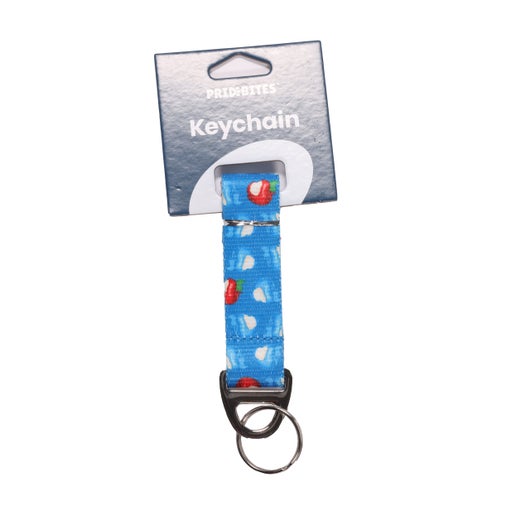 Blue keychain with black hardware. It is covered in the iconic Angry Orchard bitten red and blue apples. 