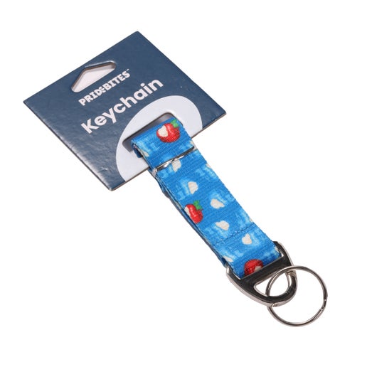 Blue keychain with black hardware. It is covered in the iconic Angry Orchard bitten red and blue apples. 