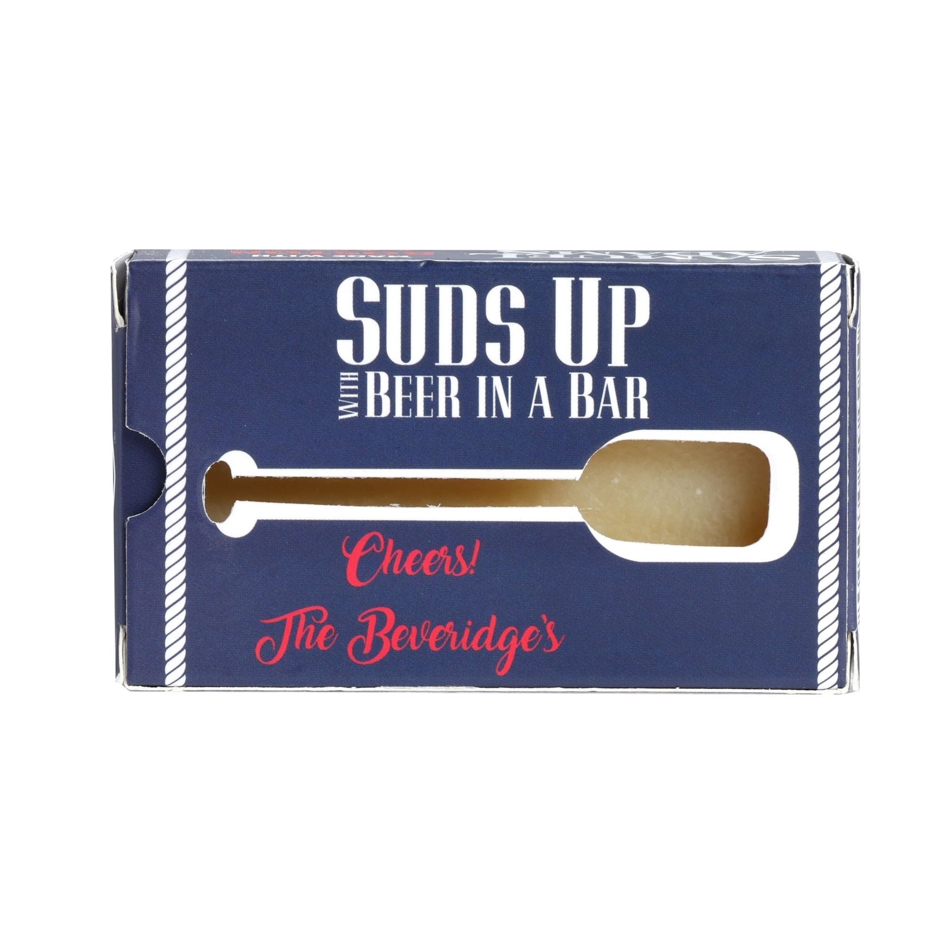 Our Beer soap made with Samuel Adams Boston Lager has a clean men's cologne scent. The soap is packaged in a navy blue box with white text and white and red details. This side of the box reads "Suds up with beer in a bar" and features a cutout in the box in the shape of a paddle to give a preview of the product.
