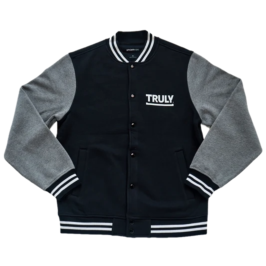 Front view of black bomber jacket with grey sleeves and white bordering around the neck, waist, and wrists. Truly logo is featured in white on the left side of chest. 