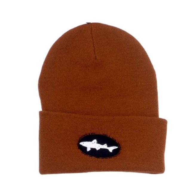 The Brown Beanie by Mirror Image Inc. is a knit winter hat with a folded brim, featuring a black oval patch and an embroidered white shark logo on the front.