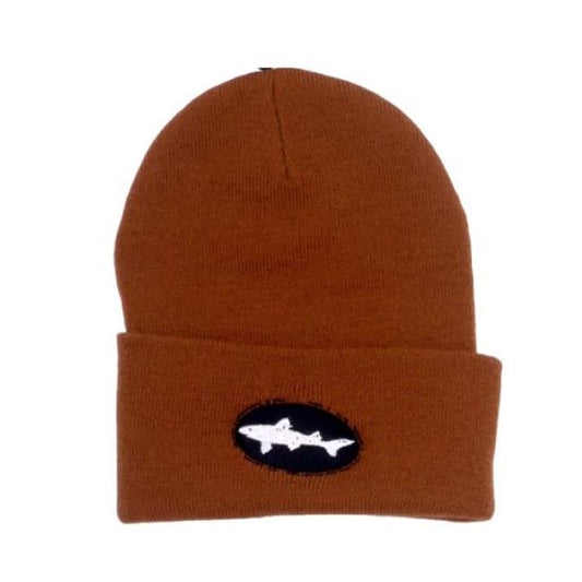 The Brown Beanie by Mirror Image Inc. is a knit winter hat with a folded brim, featuring a black oval patch and an embroidered white shark logo on the front.