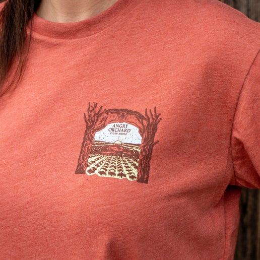 Close-up of front of tee displays a small artistic rendition of our Angry Orchard location on the left of chest.