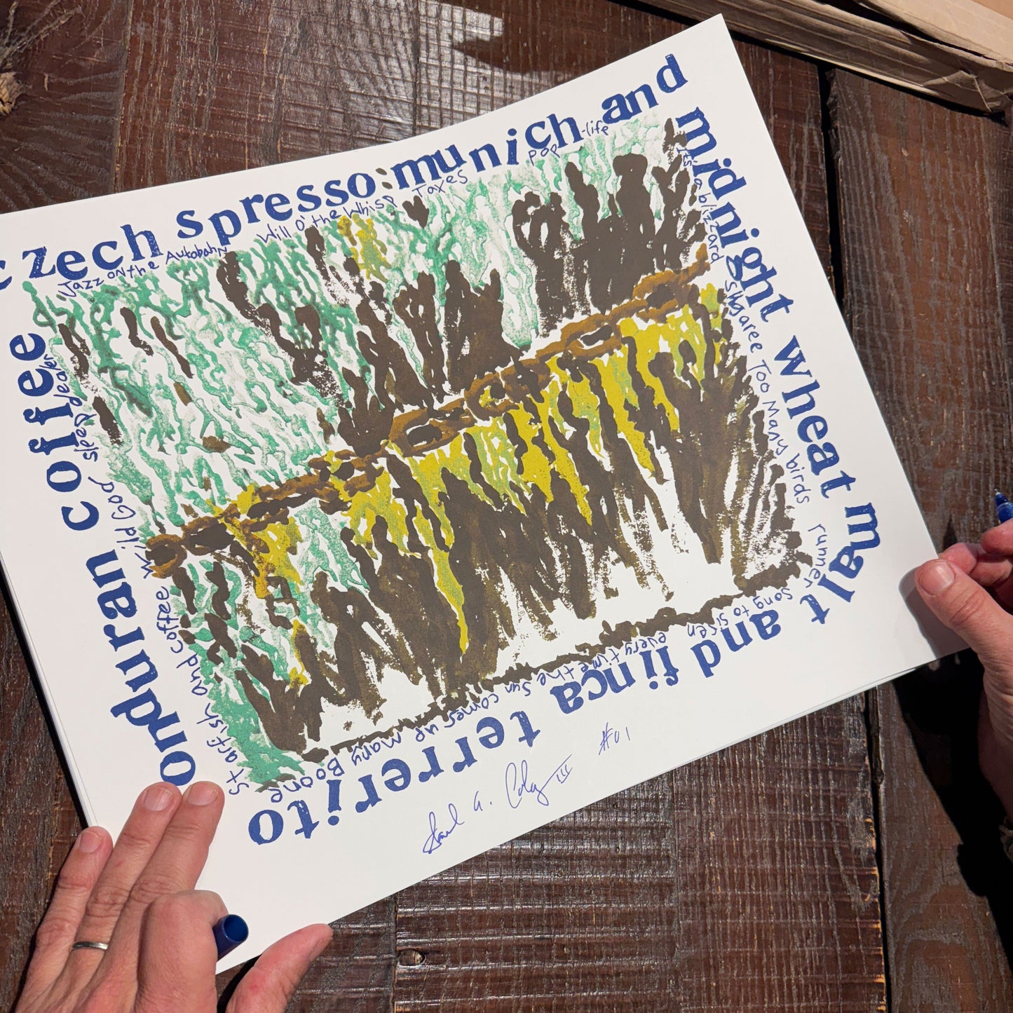 Hand-drawn illustration on a piece of paper held by hands on a wooden surface