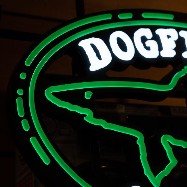 Close-up of the Merchtank Craft Brewery Logo LED Neon, showing "DOGF" in bright white letters with a green shark outline, glowing against a dark background.