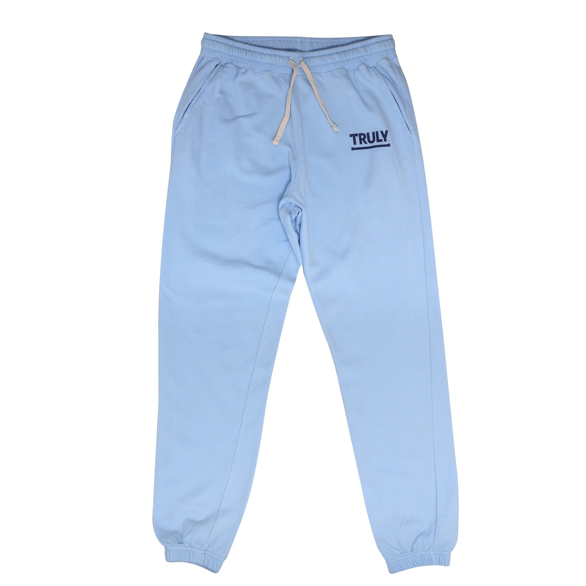 A pair of light blue sweatpants with elastic cuffs and a beige drawstring waistband. The word "TRULY" is printed in dark blue with an underline on the upper left thigh.