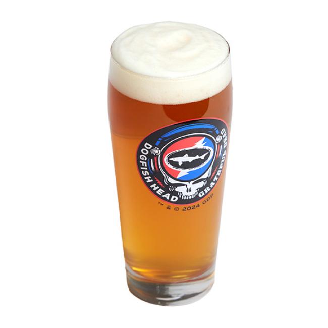 The Dogfish Head x Grateful Dead Juicy Glass by Grandstand Glassware & Apparel is shown filled with amber beer and a frothy head, featuring a shark logo. Ideal for craft beer glass collectors or Grateful Dead fans. Displayed on a clean white background.