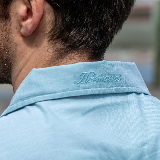 Close up of the fold over on the neck which features writing "Hermanos" on it.