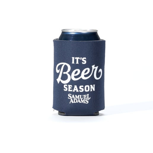 A navy blue 12oz can cooler with the slogan "It's beer season" printed over the Samuel Adams logo in white.