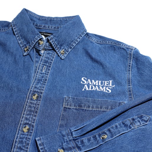 Jim Koch-inspired Jean/denim Button Up Shirt embroidered with the Samuel Adams classic logo over a pocket on the left side of the chest.