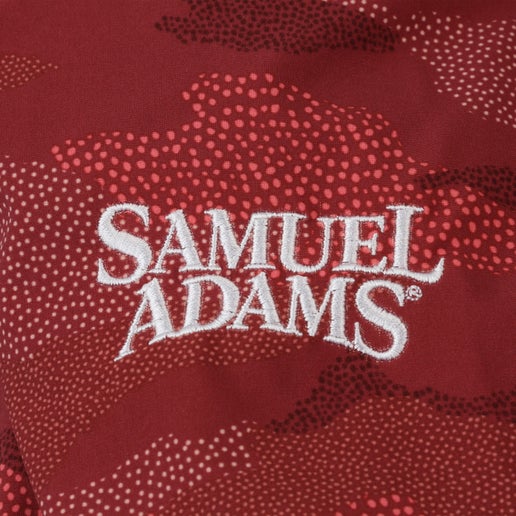 Close up of white Samuel Adams logo on KUHL W Maroon Print Dress Red camouflage print dress 