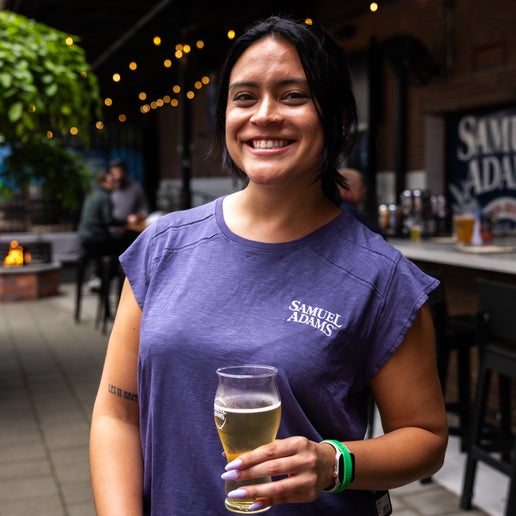 Woman drinking a Samuel Adams pint wearing a KUHL W Navy Shilo Short Sleeve Tee