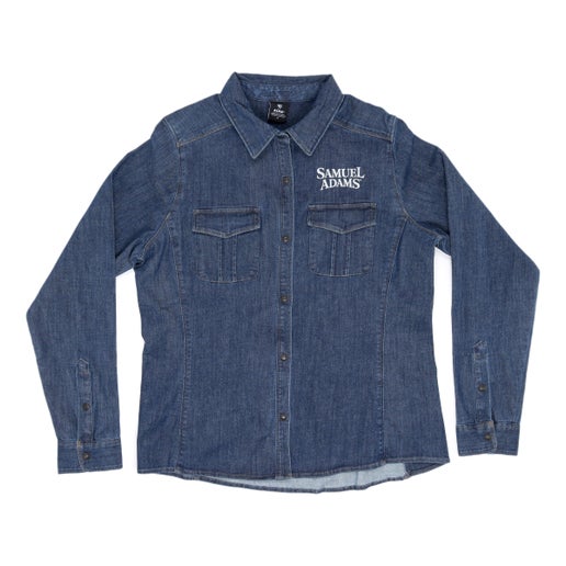 The KUHL super lightweight performance denim button-up shirt features a snap front, two front chest pockets, Princess seams, and the Samuel Adams logo embroidered over the left side chest pocket in white.