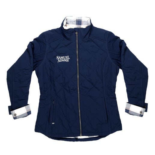 Our KUHL W Indigo Stunnr Insulated Jacket has features like a cozy flannel lining, zippered hand warmer pockets, an internal security pocket, and the Samuel Adams logo embroidered in white on the right side of the upper chest.