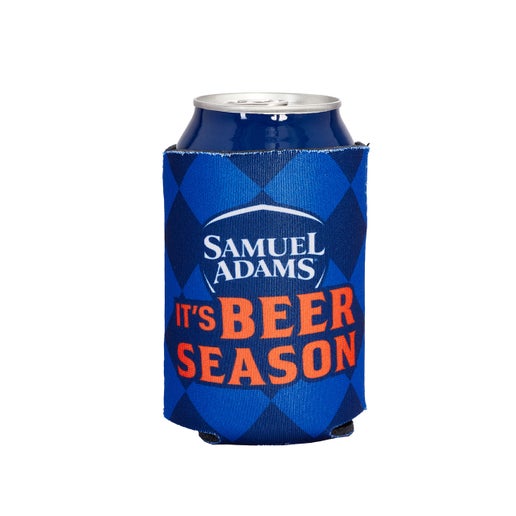 This navy Octoberfest-themed can cooler holds up to a 12oz can and has blue diamonds as a background with the Sam Adams classic shield logo over it and a slogan in orange that reads "It's Beer Season" under it.