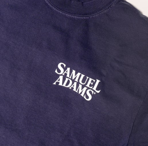Close up of Samuel Adams logo on the front left chest of a navy short sleeve shirt