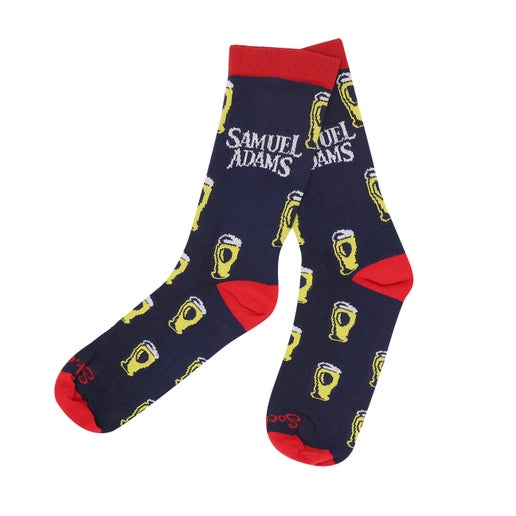 A pair of navy socks with red on the toe, heel, and top of ankle, and pints of beer with the Sam Adams logo on the ankle.