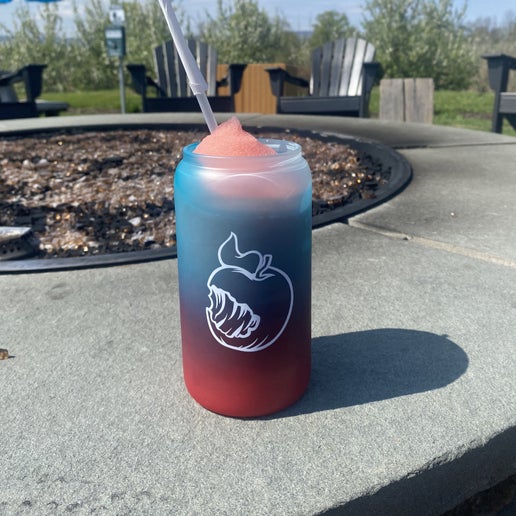 On one side of this glass is a white silhouette of the iconic Angry Orchard bitten apple. 
