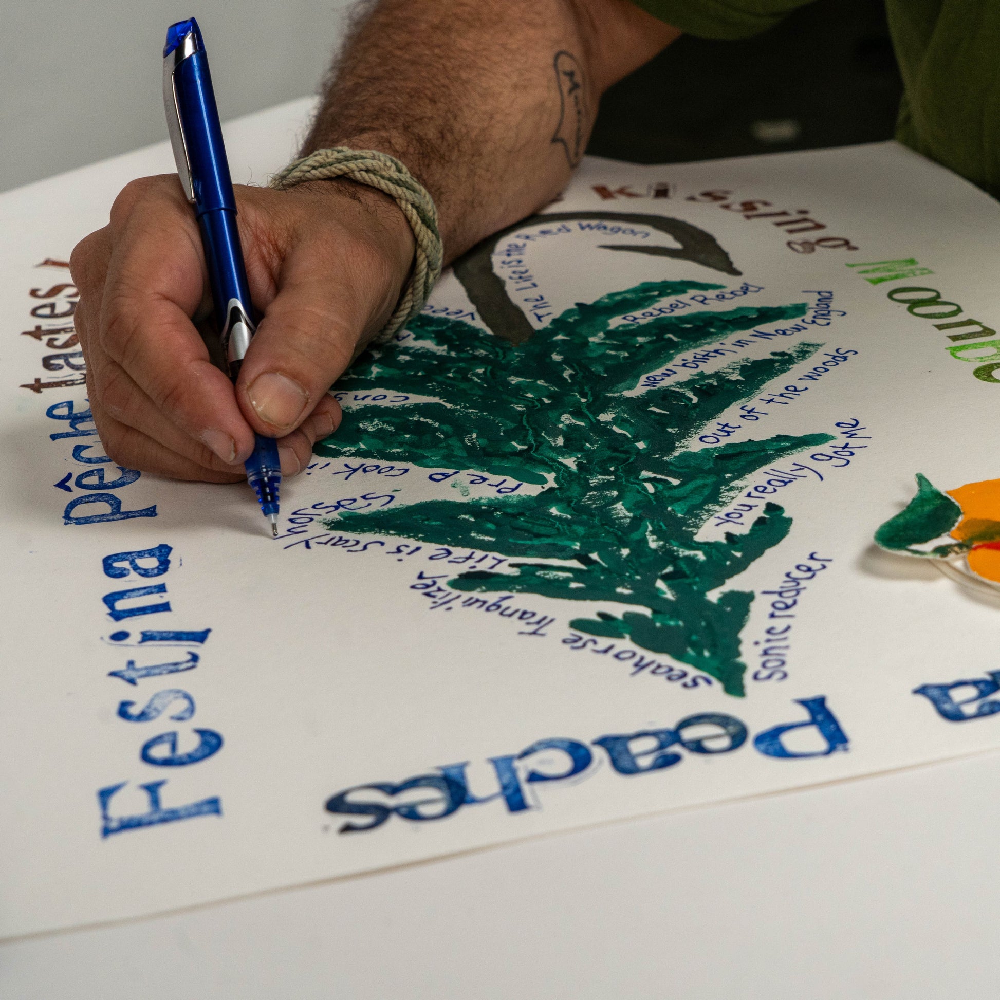 Close-up of hand lettering on Festina Peche screen print poster, featuring a green tree illustration, peach graphic, and song and lyric typography created with pen and ink.