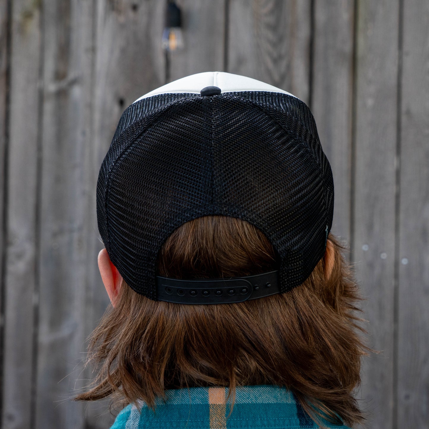 Back view of Dogfish Head x Crispy Pizza trucker hat with black mesh panels and adjustable snapback closure on white and black cap