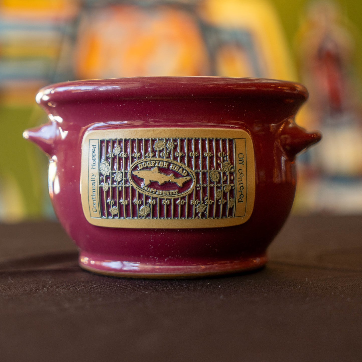 Red ceramic crock with a taupe label on a dark surface