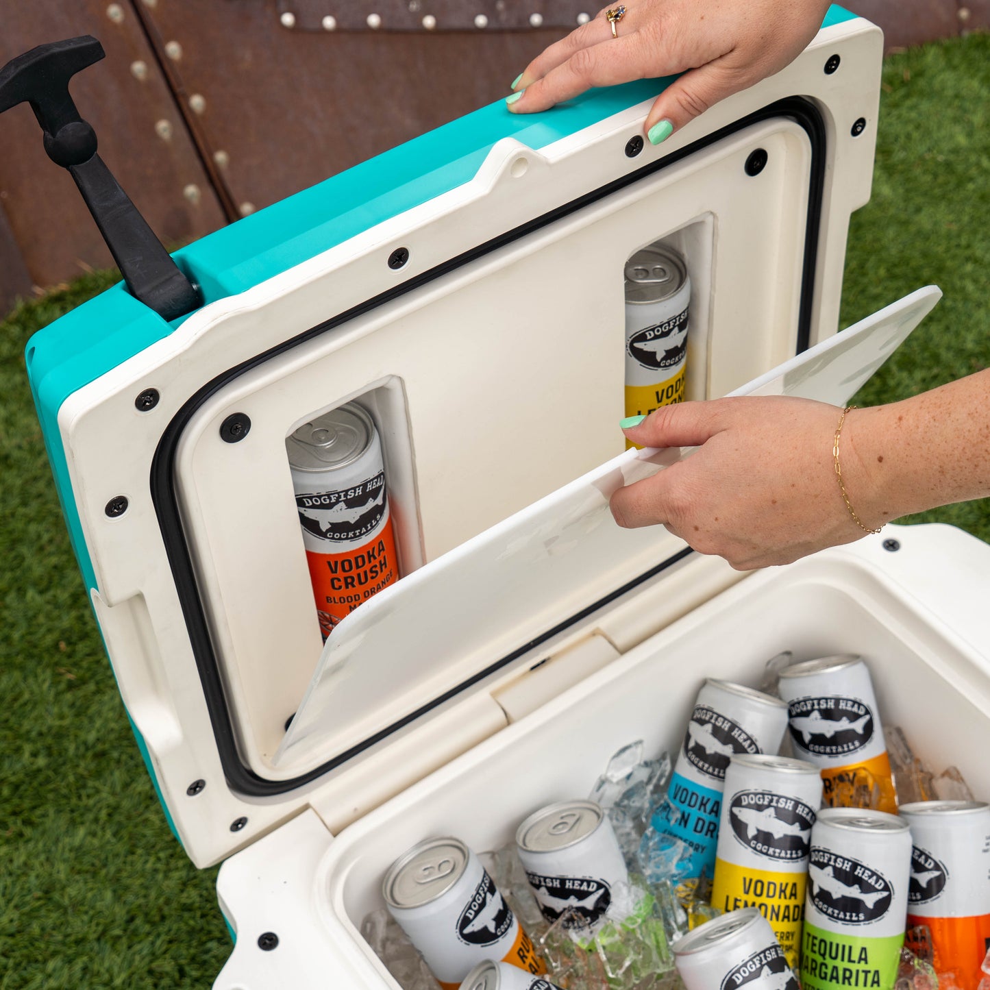 Cooler with open door showing drinks inside, on grass