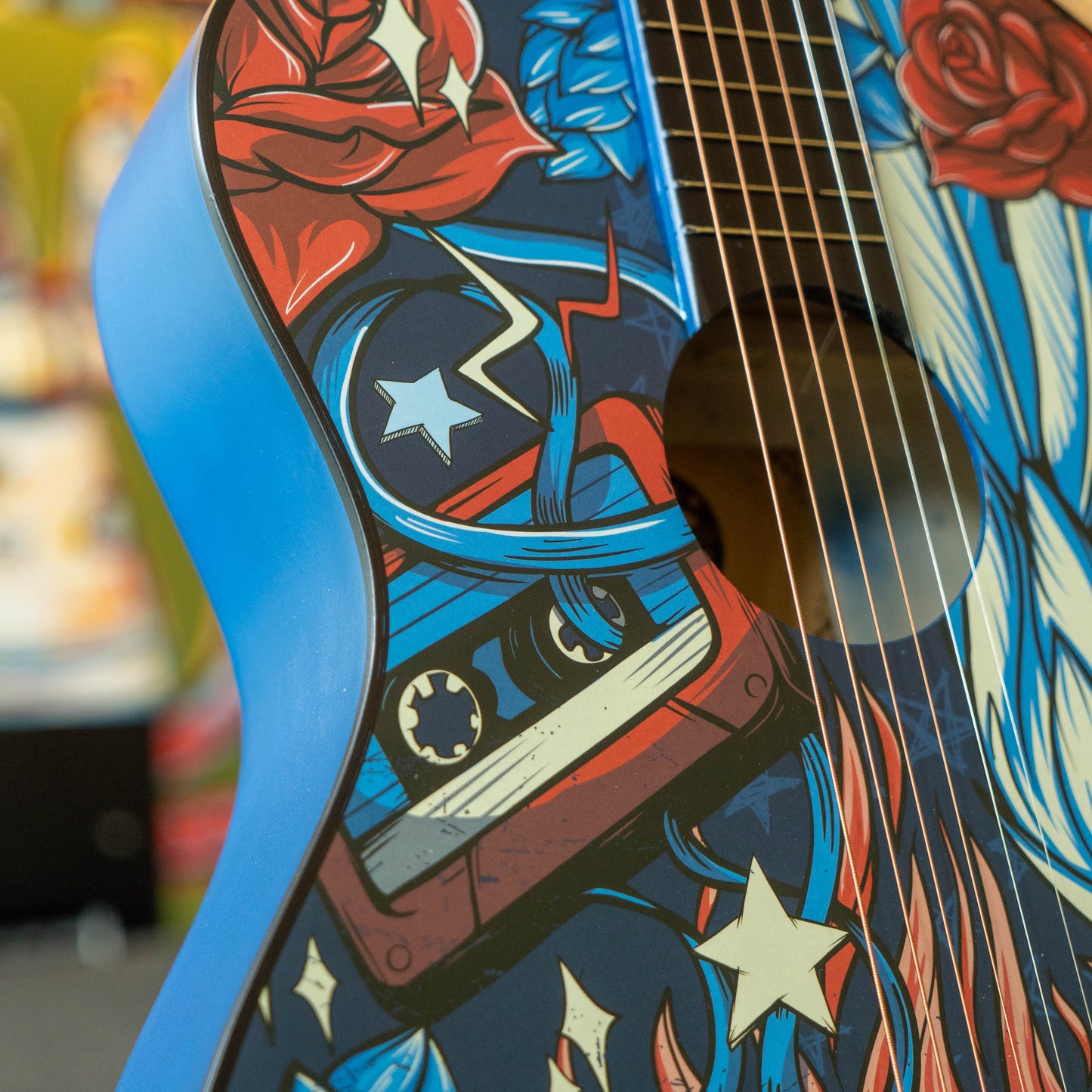 Close-up of a guitar with colorful design featuring stars and stripes.