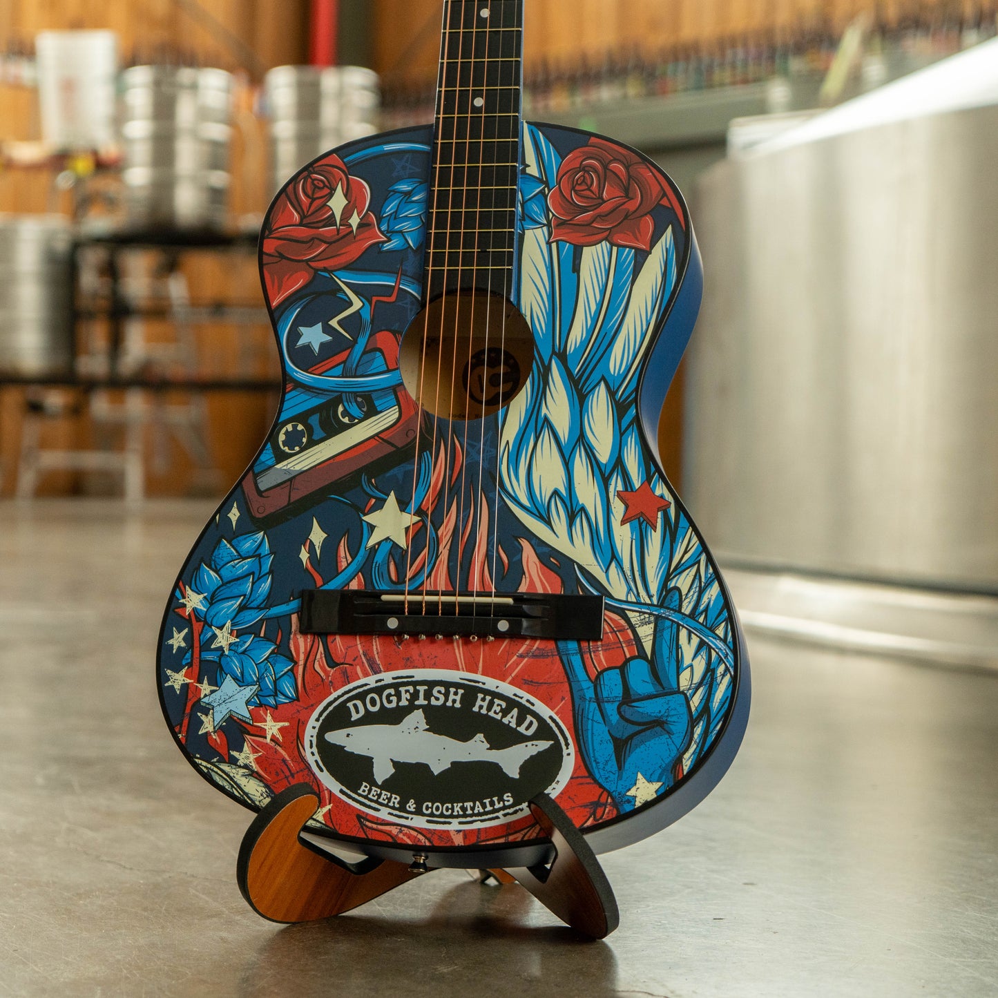 Decorative guitar with colorful design and 'Dogfish Head' logo on a stand.