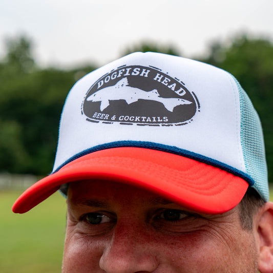 Person wearing a white and red cap with 'Dogfish Head' logo outdoors